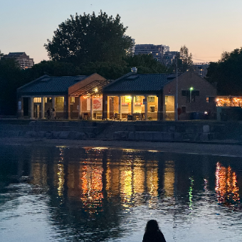 A boathouse at dusk reflected in the water